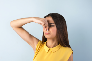 鼻をつまむ女性